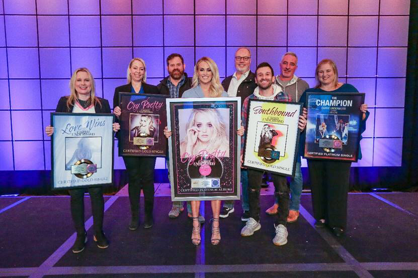 From left to right: Cindy Mabe (President, UMGN), Ann Edelblute (Owner, The HQ), Royce Risser (EVP of Promotions, UMGN), Carrie Underwood, Mike Dungan (Chairman & CEO, UMGN), David Garcia (Underwood’s Co-Producer), Brian Wright (EVP of A&R, UMGN), Jackie Jones (Vice President, Artist & Industry Relations, RIAA)   Photo Credit: Country Radio Seminar 2020/Kayla Schoen